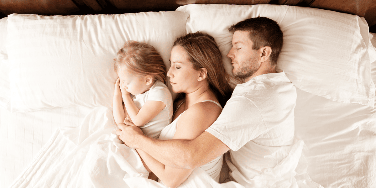 Mother and child sleeping peacefully on a clean bed